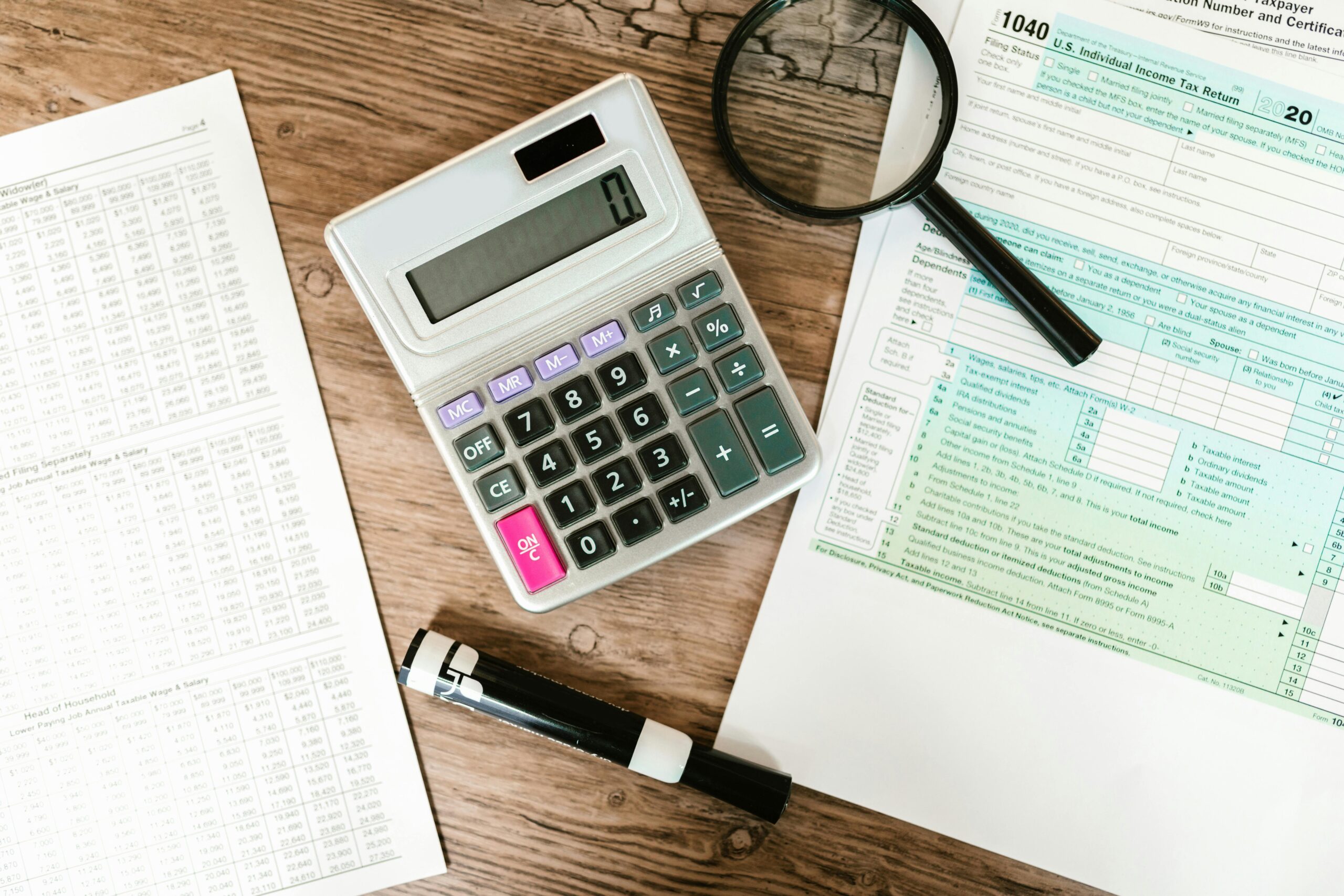 Calculator on desk, with accounting documents on either side of it.